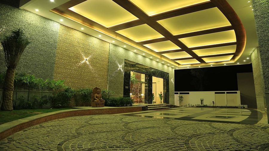 Well-lit entrance of Dhanalaksmi Srinivasan Hotels, Perambanur with a pathway leading to the door.