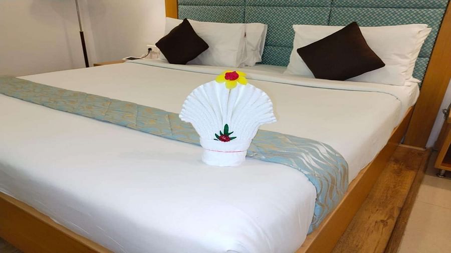 Close up of a Executive Suite at Dhanalakshmi Srinivasan Hotels, Perambalur featuring a bed with white linens and towel on it.