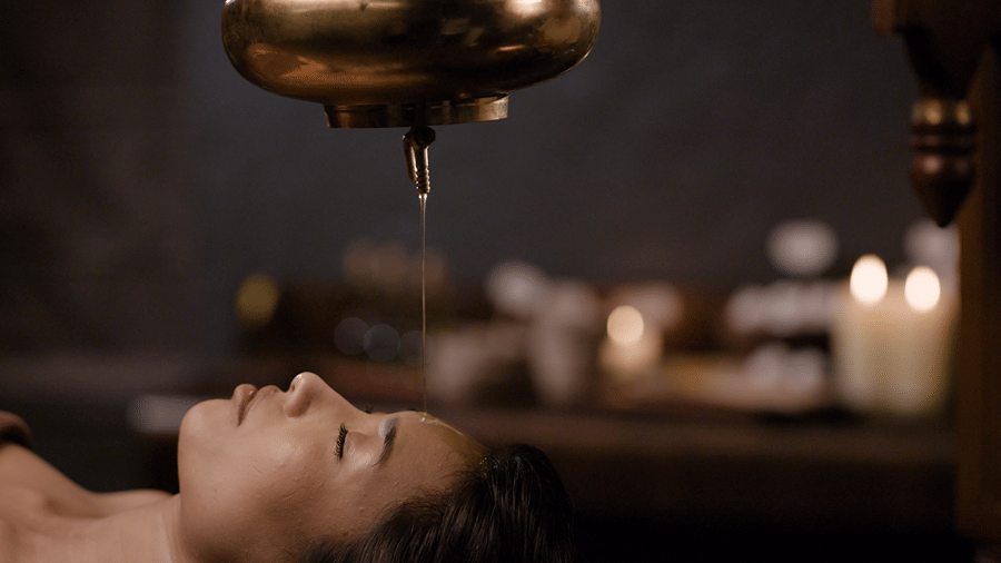 Traditional Ayurvedic Shirodhara therapy at Kavya Himalayas, featuring a gentle stream of warm oil poured onto the forehead for deep relaxation.