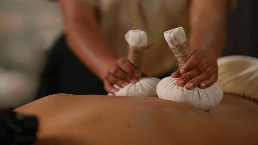 Traditional Ayurvedic Patra Potali Sweda therapy at Kavya Himalayas, using warm herbal poultices for a soothing body treatment.