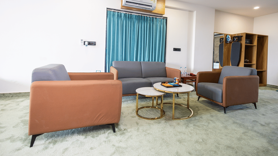 A stylish living space with armchairs and a coffee table, opening into a well-appointed bedroom.