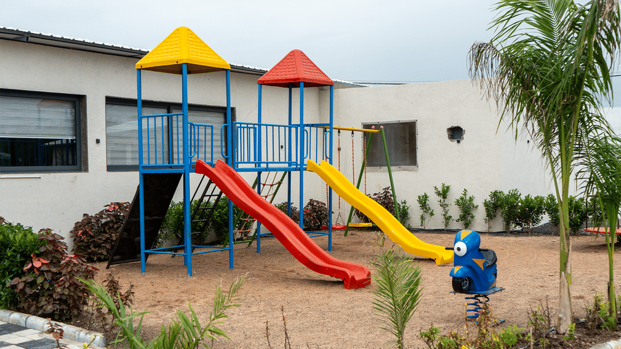 Outdoor kids play area with slides and garden setting at Lords SKD Resort, Salangpur.