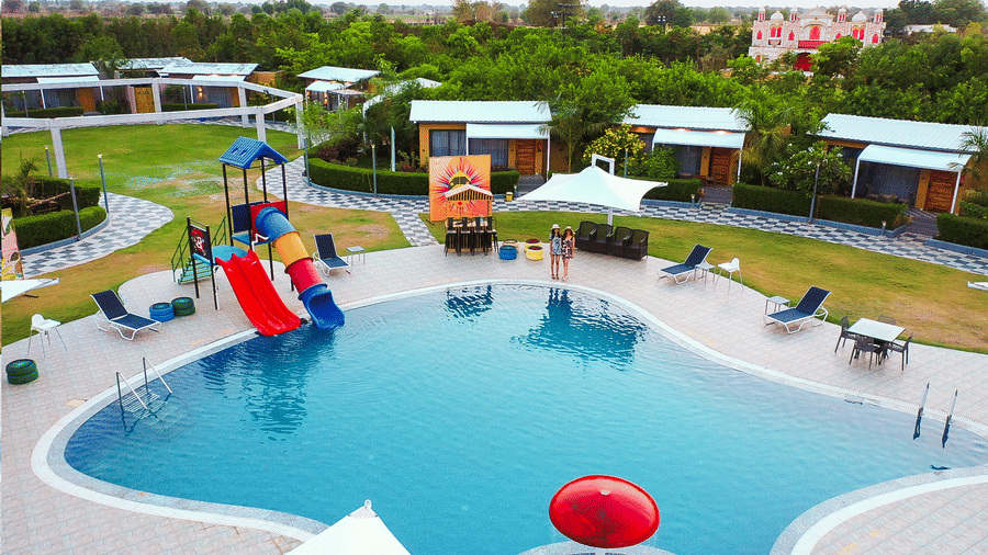 Swimming pool with slides and surrounding seating at Lords SKD Resort, Salangpur.