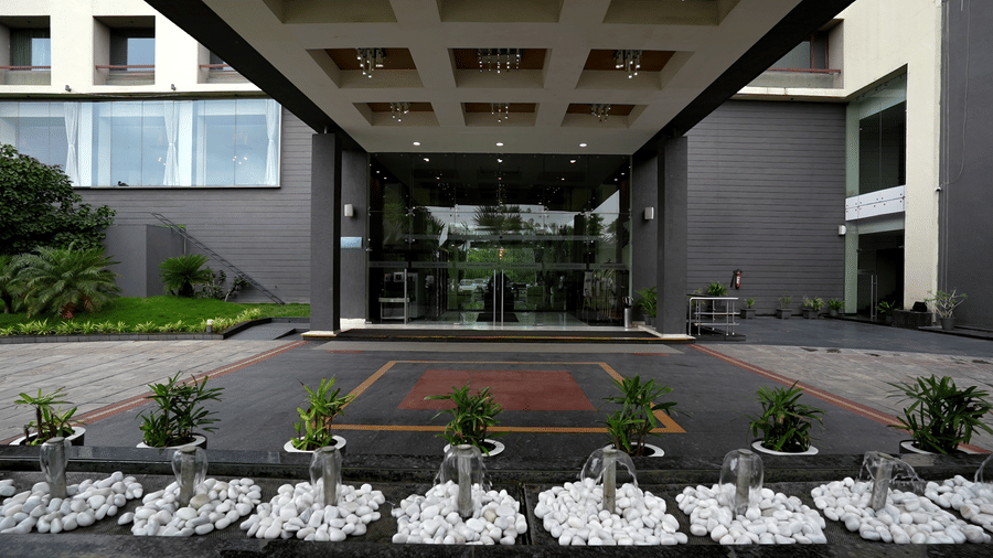 Entrance of the hotel with landscaped garden at Narayani Heights Hotel & Resorts, Ahmedabad.