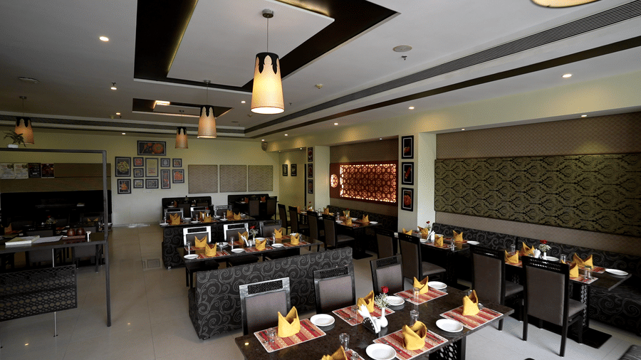 Spacious restaurant interior with ambient lighting and stylish table arrangements - Narayani Heights Hotel & Resorts