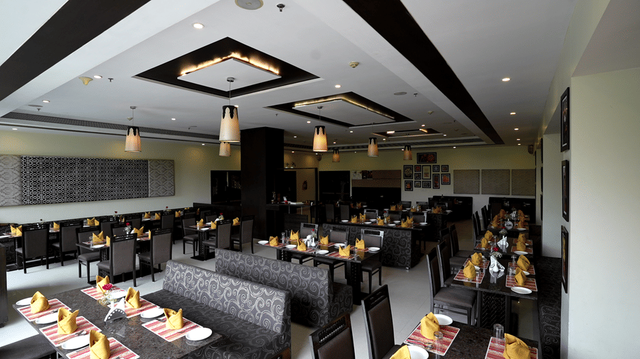 Wide-angle view of the hotel dining area with contemporary seating and lighting - Narayani Heights Hotel & Resorts