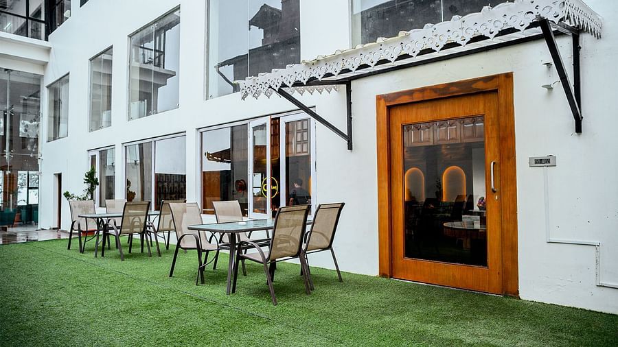 A wide shot of an outdoor dining area with white buildings in the background at Orsino Spa Resort.