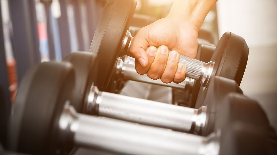 a person holding a dumbbell at Rhythm Gurugram