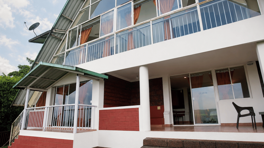Close view of a chalet at Wind Chalet, featuring a covered veranda, upper level with large windows, and outdoor seating area.