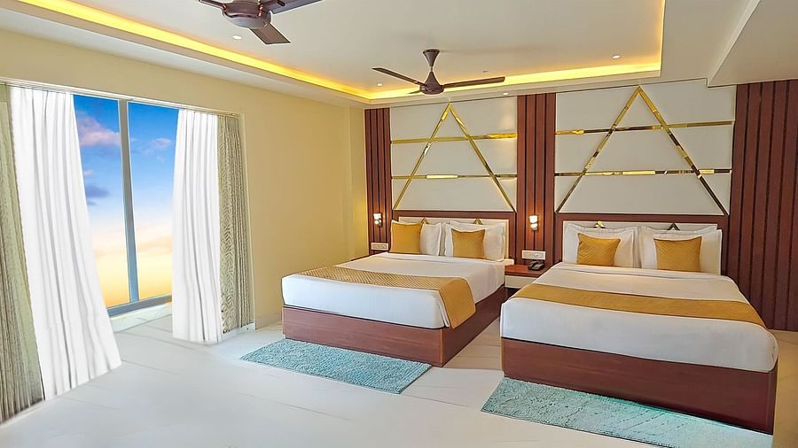 Suite featuring two king size beds with geometric headboards, sheer curtains, and a view of the outdoors at Yashshree Bangla Queen, Digha.