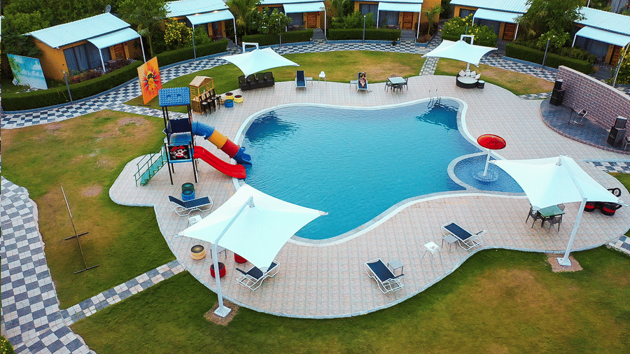 Pool area with slides, loungers, and landscaped surroundings at Lords SKD Resort, Salangpur.
