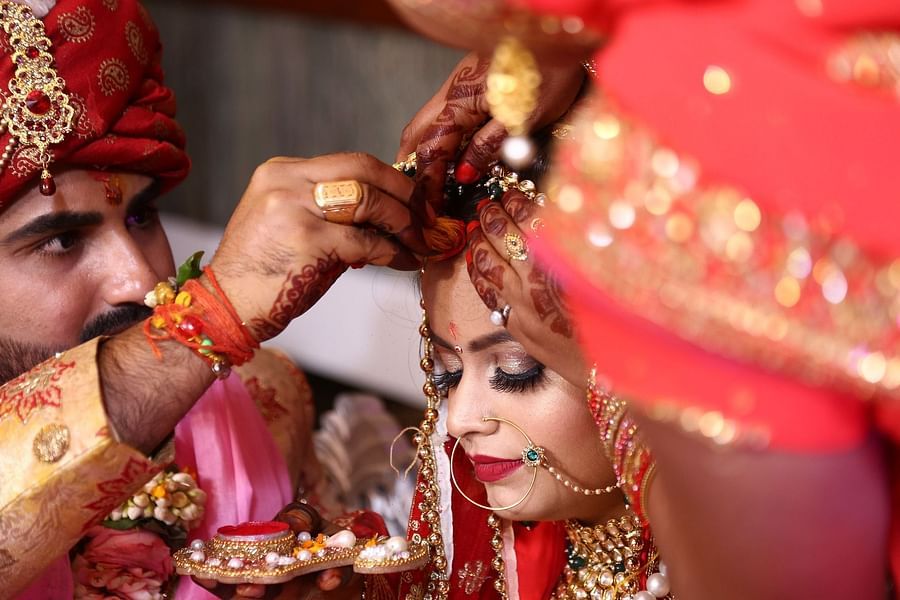 husband putting vermilion on his wife during their marriage ceremony
