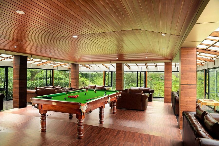 Shot of a billiard table at the hall of the villa Shot of the balcony at the villa with chairs kept | Ibex Stays and Trails, Valparai (Tale Rock)