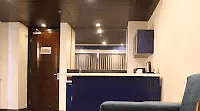 A comfortable couch with an ottoman in front. A glimpse into another area with an open layout.- Golden Suites, Gurgaon