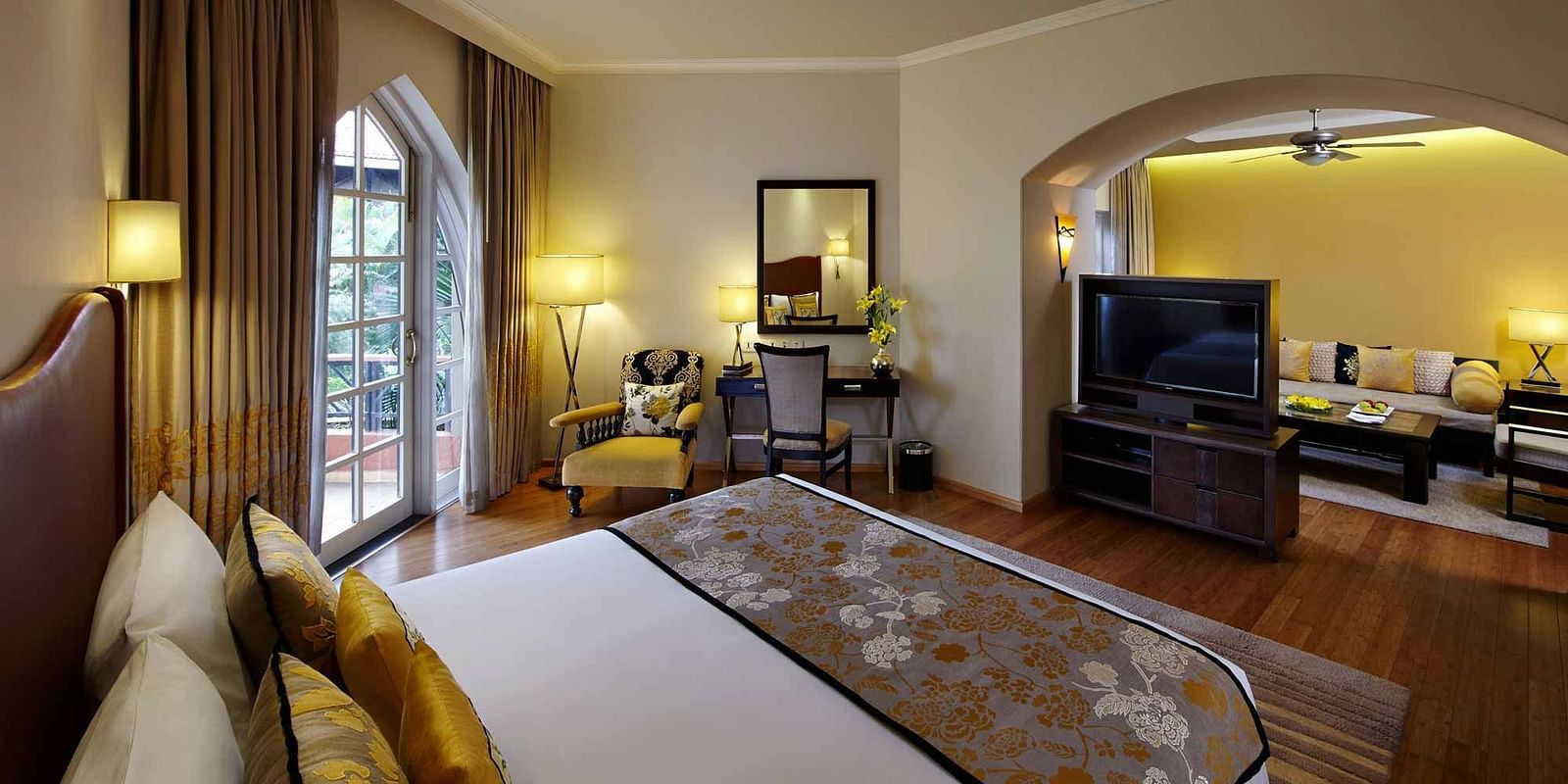A luxurious hotel suite featuring a cozy bedroom and a separate living area, elegantly decorated for a comfortable stay.