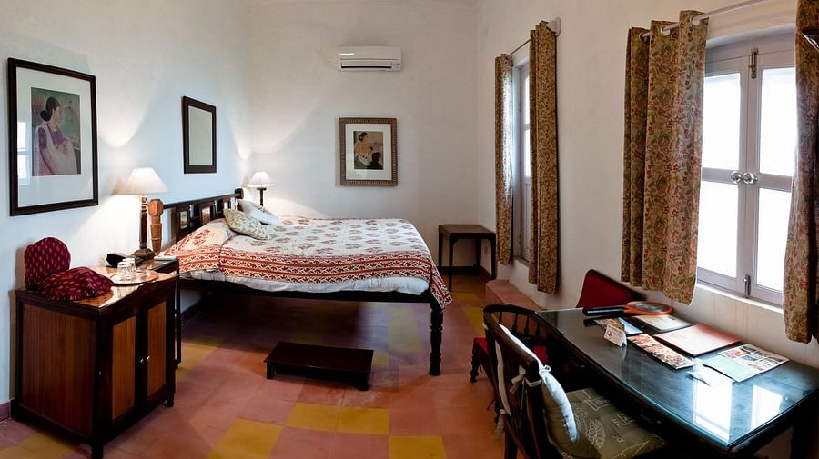 Simurg Mahal is equipped with a bed, wooden furniture, large windows and a drawer - Royal Hotels in Alwar