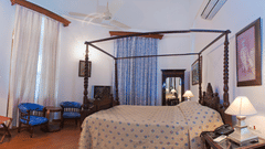An overview of the Kaursahib Ranbir Singh room with a double bed, single seater and a small table - The Baradari palace