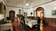 A dining table inside a room with beautifully crafted wooden chairs - Wallwood Garden - 19th Century, Coonoor