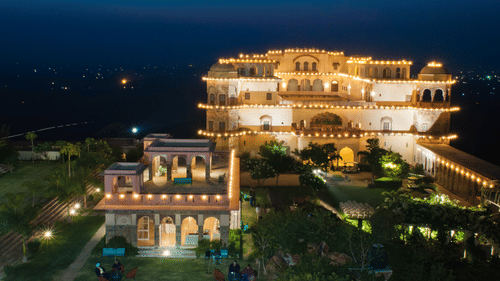 A far out facade view of Tijara Fort-Palace, Alwar in the night with the lights on.