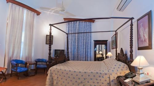 An overview of the Kaursahib Ranbir Singh room with a double bed, single seater and a small table - The Baradari palace