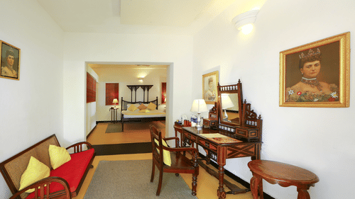 The Tower House - The Albuquerque room with a grand mirror and a couch in front. the room also showcases an inner room with a queen size bed