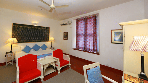 The Tower House - The Pacheco room with simple interior and red couch in front of the queen size bed