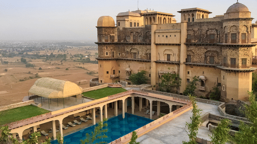 Facade view of Tijara Fort-Palace - 19th Century, Alwar with clear blue sky in the background.