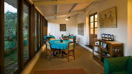 A round table with blue cloth on top and 4 chairs surrounding it - Wallwood Garden - 19th Century, Coonoor