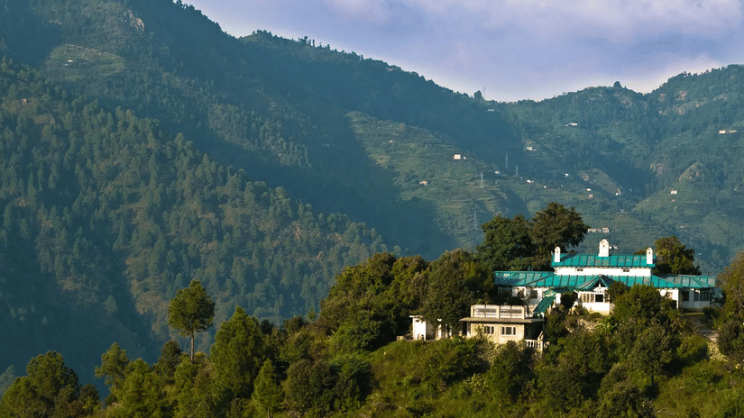 Aerial view of The Ramgarh Bungalows 19th Century Hotel, overlooking forested mountains and valleys in Nainital.