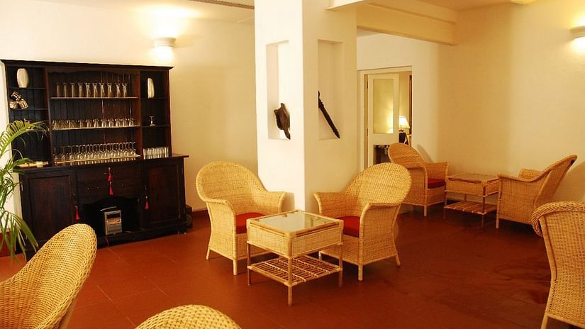 The Tower House - a dining and lounge area featuring a wooden shelf that holds glasses to drink alcohol