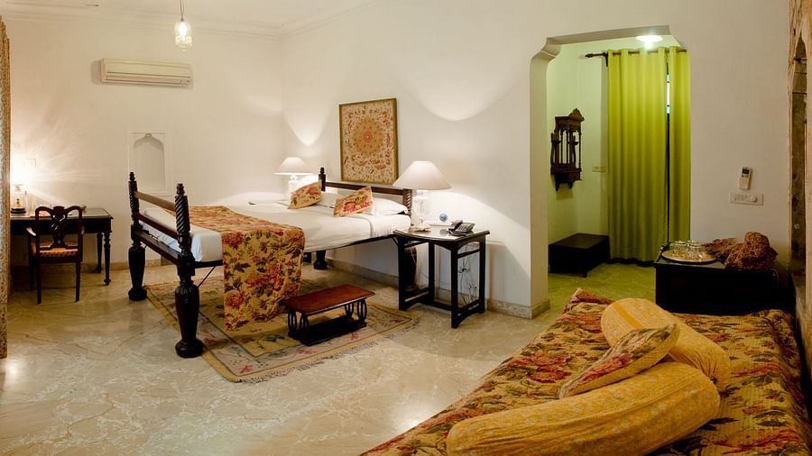 Deo Bagh - 17th Century, Gwalior - view of a bed and a seating sofa in the corner at Aruna Vilas