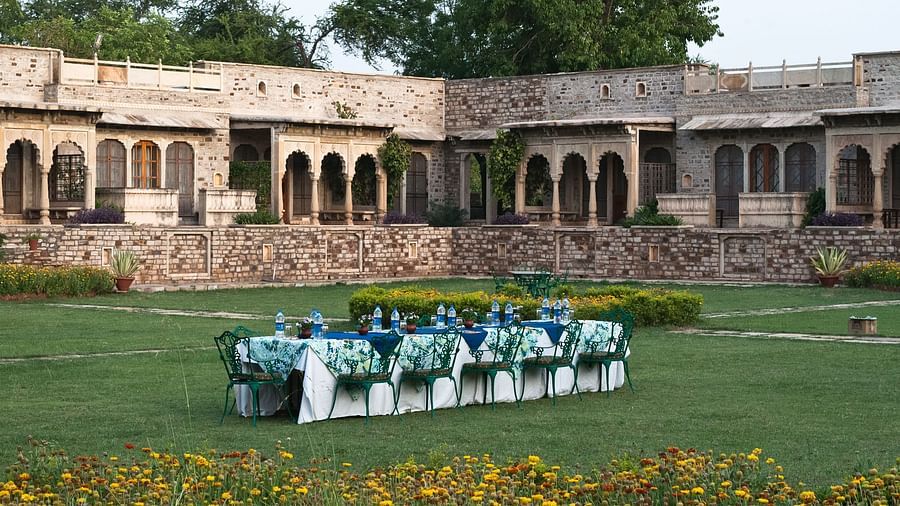 Deo Bagh - 17th Century, Gwalior - an outside dining seating arrangement made in the centre of the garden with the resort in the backdrop