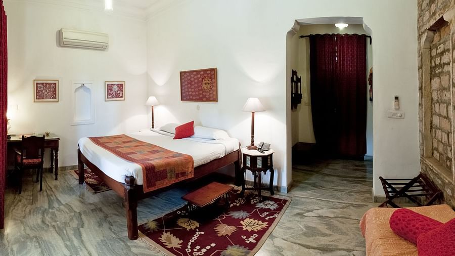 Deo Bagh - 17th Century, Gwalior - view of the bed and a carpet kept under it at the Hiroji Ratna - Naubagh / Garden View room in Gwalior