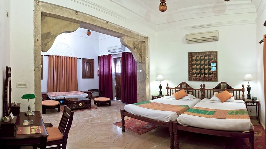 Deo Bagh - 17th Century, Gwalior - twin sharing beds and a work station offered at the Rohini Raja Mahal room in Gwalior