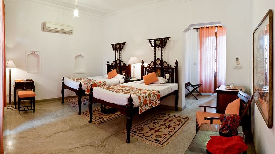 Deo Bagh - 17th Century, Gwalior - view of twin sharing beds and a sofa in the corner at the Sunita Mahal room in Gwalior
