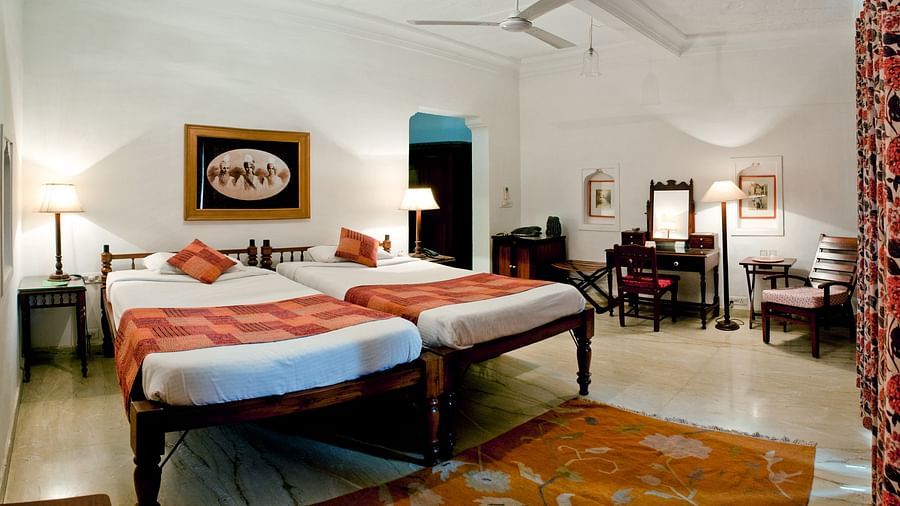 Deo Bagh - 17th Century, Gwalior - twin sharing beds and a wall painting hanging on top of the beds at the Sushila room