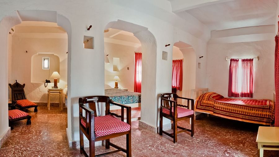Hill Fort Kesroli 14th Century Alwar - interior view of the Nirmal Mahal - Pool View with numerous seating options, and red decor