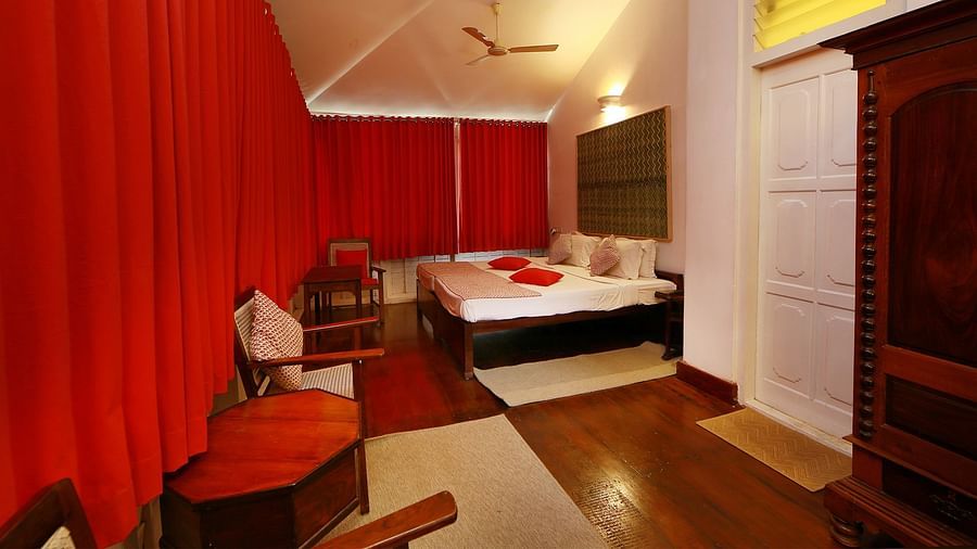 The Tower House -  The Breekopt room with red curtains and a king size bed with white linens and a coffee table
