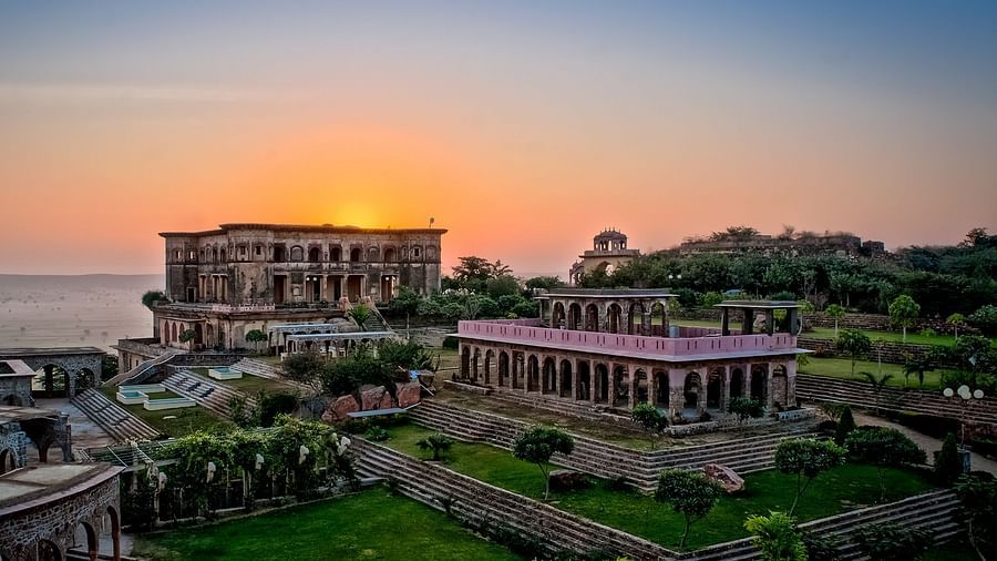 Facade shot of Tijara Fort-Palace - 19th Century, Alwar with orange hued sky in the background.