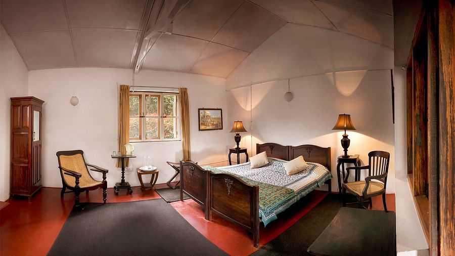 A double bed with a chairs, side tables, lamps and wardrobe - Wallwood Garden - 19th Century, Coonoor