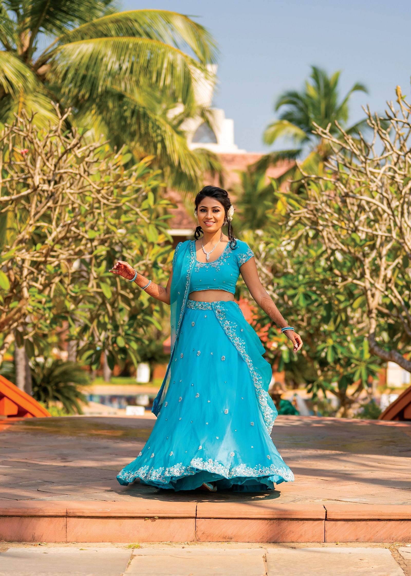 a woman posing for a picture with greenery in the background - Caravela Beach Resort Goa