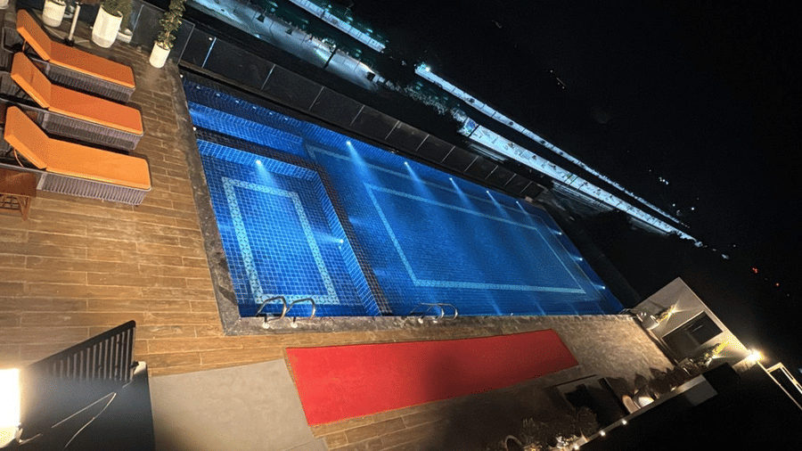 The swimming pool at Le ROI Digha Hotel, West Bengal, featuring a poolside seating area with lounge chairs.