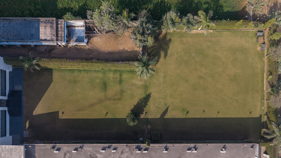 Hotel Highway Prince Paota top-down aerial view of open green lawn area with surrounding boundary walls, ideal for outdoor events.
