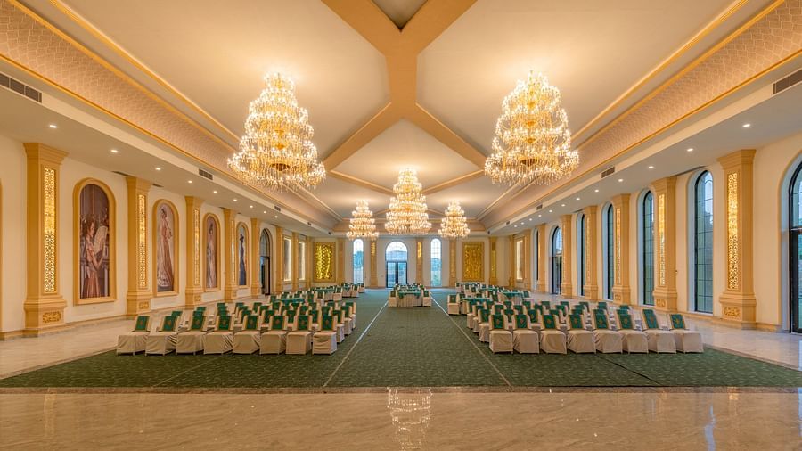 Front view of a banquet hall with neatly arranged chairs and chandeliers adorning the ceiling at Valley by Grassfield.