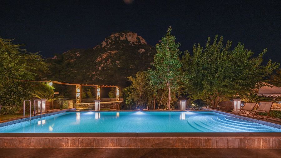 Night view of a swimming pool surrounded by plants at Valley by Grassfield.