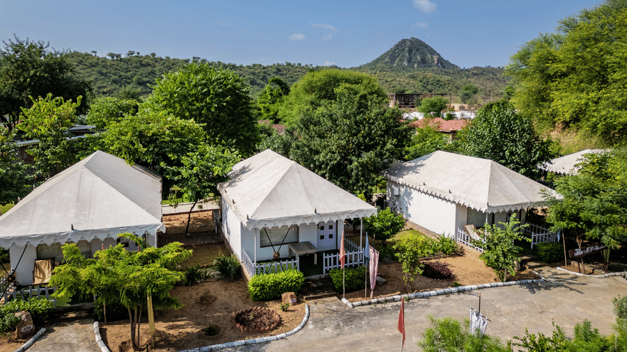 Aerial view of Swiss tent accommodations amid trees at Valley by Grassfield, a tented resort in Jaipur.
