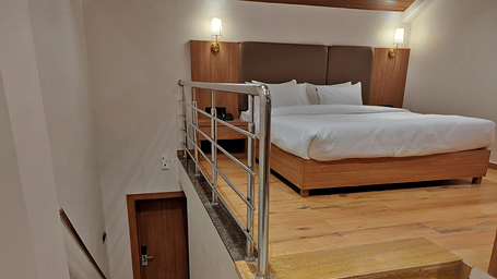 Loft-style bedroom with a double bed, bunk bed, wooden steps, and railing