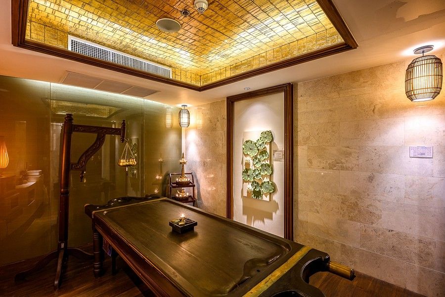 alt-text corner view image of the maikhao dream spa with a wooden bed in the middle and door in the corner of the room