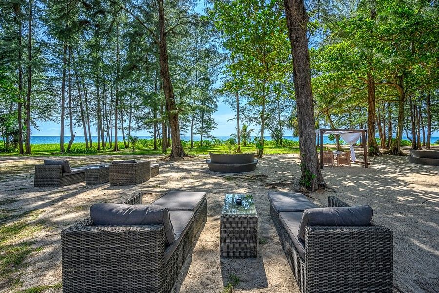 alt-text well arranged dining area amidst tall green trees and a clear blue sky - Maikhao Dream Villa Resort & Spa, Phuket