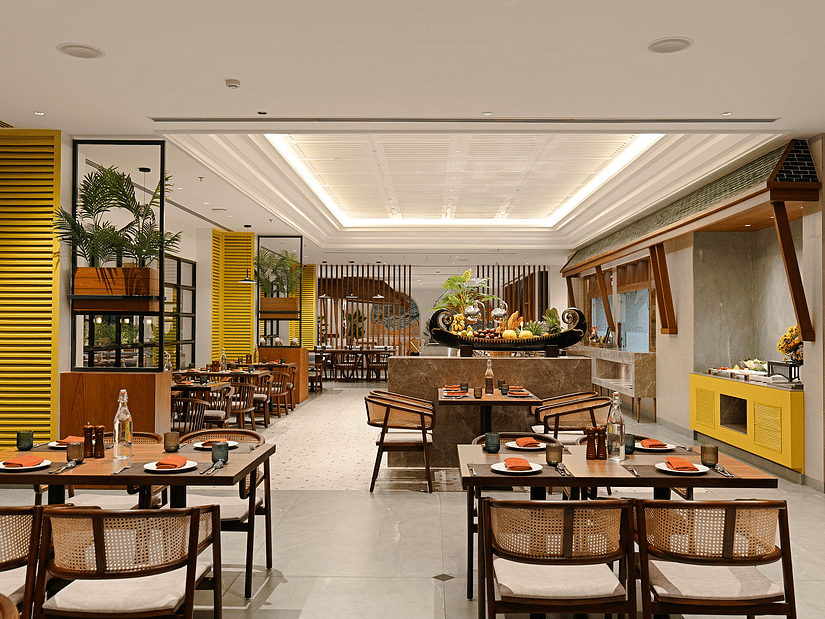 A spacious dining area with neatly arranged tables, chairs, and a well-set culinary layout awaits guests at Cloud9 Sarovar Premiere, Palolem Goa